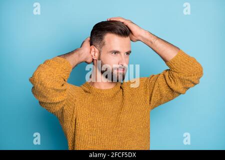 Photo de jeune beau positif beau homme beau look copyspace fixation coiffure isolée sur fond bleu Banque D'Images