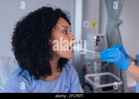 Femme afro-américaine avec ouverture de la bouche testée avec un écouvillon test Banque D'Images