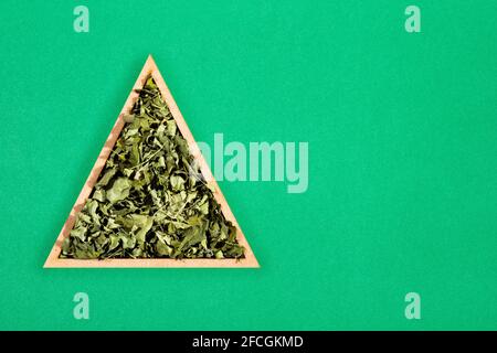 Feuilles de moringa séchées dans un bol triangulaire - Moringa oléifera Banque D'Images