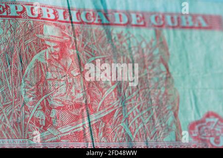 Au contraire du billet de trois pesos cubains montrant le leader communiste révolutionnaire Che Guevara coupant la canne à sucre. Billet de banque usagé, photographié à un Banque D'Images