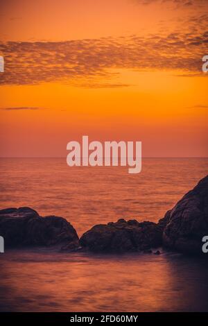 Coucher de soleil coloré et formation de rochers au premier plan avec vagues qui s'écrasant vue depuis le fort hollandais de Galle soir, après le coucher du soleil heure bleue, longue exposition ve Banque D'Images