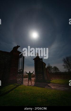 Lauder, Royaume-Uni. 23 avril 2021. Météo Royaume-Uni. La vue de ce soir sur les portes de l'aigle du château de Thirlestane à Lauder, comme un cercle corona est visible autour de la lune de gibbous cirant alors qu'une autre nuit froide voit les températures se tremper jusqu'au point de congélation. Crédit : phil wilkinson/Alay Live News Banque D'Images