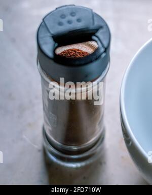 Café instantané en poudre dans une petite bouteille en verre transparent et un bol blanc pour fouetter dans la mousse, temps de préparation du café Dalgona dans la cuisine. Banque D'Images