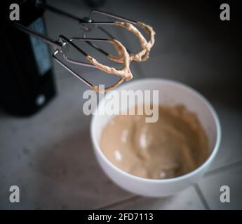 Faire une célèbre boisson coréenne également connue sous le nom de café Dalgona, en chuchotant le café instantané dans un bol avec un batteur électrique dans la cuisine maison, l'eau de sucre Banque D'Images