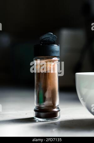 Café instantané en poudre dans une petite bouteille en verre et un bol blanc pour fouetter dans la mousse, temps de préparation du café Dalgona dans la cuisine maison. Banque D'Images