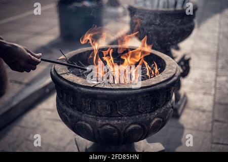 Bâtonnets d'encens brûlants en pierre Jaya Sri Maha Bodhi Anuradhapura, une vieille main avec des bâtons d'encens, pèlerin éclairant ses bâtons du feu, p Banque D'Images