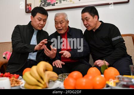 (210424) -- TAIYUAN, 24 avril 2021 (Xinhua) -- Zhang Shiqi (L) montre des photos de nouveaux équipements miniers utilisés à la mine de du'erping du Groupe de charbon de Coking Shanxi à son grand-père (C) et à son père dans la province de Shanxi, dans le nord de la Chine, le 22 avril 2021. Zhang Lianggui, son fils Zhang Hai et son petit-fils Zhang Shiqi avaient tous travaillé comme mineurs de charbon. L'histoire de cette famille de mineurs de charbon sur trois générations illustre l'essor de l'industrie minière chinoise, de l'activité humaine à celle de la technologie. Près de 90 ans, Zhang Lianggui est un mineur à charbon à la retraite. Recruté en 1954, il se souvient t Banque D'Images