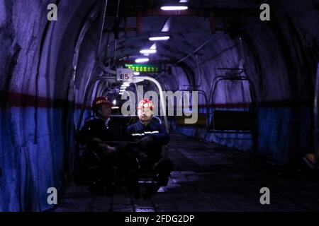 (210424) -- TAIYUAN, 24 avril 2021 (Xinhua) -- Zhang Shiqi (R) travaille avec ses collègues dans un tunnel minier à la mine de du'erping de Shanxi Coking Coking Coal Group, dans la province de Shanxi, dans le nord de la Chine, le 18 mars 2021. Zhang Lianggui, son fils Zhang Hai et son petit-fils Zhang Shiqi avaient tous travaillé comme mineurs de charbon. L'histoire de cette famille de mineurs de charbon sur trois générations illustre l'essor de l'industrie minière chinoise, de l'activité humaine à celle de la technologie. Près de 90 ans, Zhang Lianggui est un mineur à charbon à la retraite. Recruté en 1954, il rappelle les conditions de travail difficiles des mineurs de charbon Banque D'Images