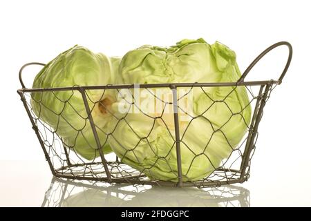 Deux têtes de chou parfumées vert vif dans un panier, gros plan, isolées sur blanc .. Banque D'Images