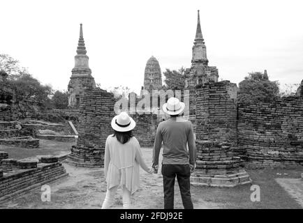 Image monochrome d'un jeune couple visitant les incroyables ruines du temple dans le parc historique d'Ayutthaya, région centrale de la Thaïlande Banque D'Images