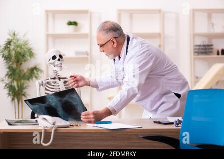 Squelette de cigarette dépendance patient visitant le vieux médecin mâle Banque D'Images