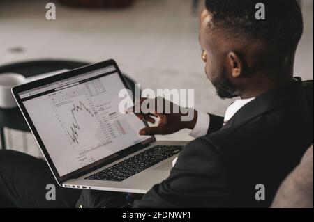 Faites toujours un effort total, même lorsque les chances sont contre vous. L'homme d'affaires afro-américain travaille, utilisant son ordinateur portable tout en se reposant dans le café Banque D'Images