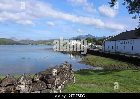 Distillerie Talisker sur l'île de Skye avec les montagnes Cuilin en arrière-plan. Banque D'Images