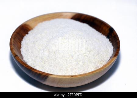 Noix de coco râpée dans un bol en bois brun, copeaux de noix de coco frais isolés sur fond blanc Banque D'Images