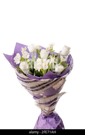 Bouquet de fleurs dans un emballage violet gros plan. Roses blanches et alstroemeria blanche dans un luxueux bouquet. Banque D'Images