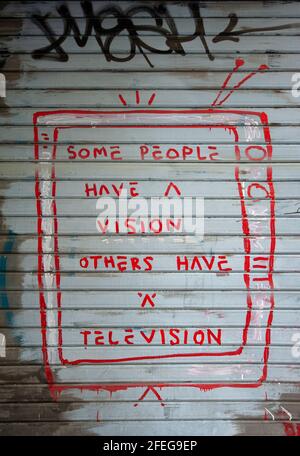 Graffiti ironique sur la télévision, sur une porte de magasin. Banque D'Images
