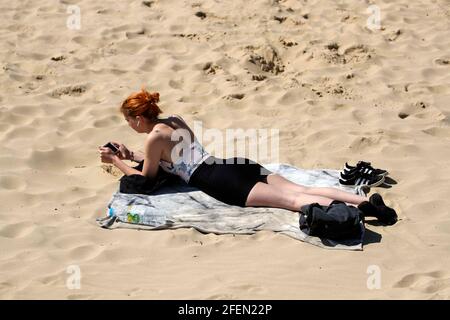 Une dame se fait bronzer sur la plage de Bournemouth à Dorset. Date de la photo: Samedi 24 avril 2021. Banque D'Images