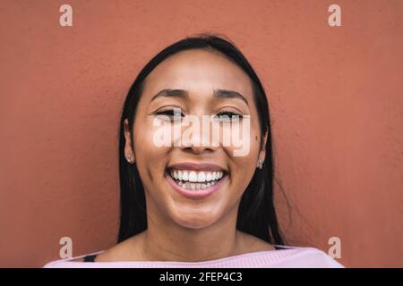 Portrait d'une jeune femme hispanique heureuse souriant devant appareil photo Banque D'Images