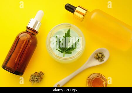 Cosmétiques de cannabis, huile de cbd. Extrait de marihuana en cosmétologie. Pose à plat, fond jaune. Détente à la maison, loisirs au spa, passe-temps. Banque D'Images