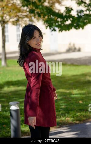 Belle femme chinoise avec de longs cheveux noirs le jour d'automne ensoleillé dans la ville, Banque D'Images