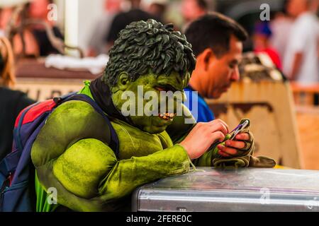 Homme en costume de Hulk avec son téléphone dans ses mains À Times Square Banque D'Images