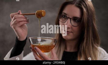 Jeune femme avec un bol de miel Banque D'Images