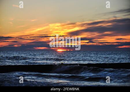 Ambiance nocturne sur la mer Baltique. Le soleil coule de façon spectaculaire entre les nuages dans la mer Banque D'Images