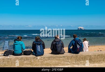 North Berwick, East Lothian, Écosse, Royaume-Uni, 24 avril 2021. Météo au Royaume-Uni : le soleil au bord de la mer : le temps ensoleillé attire la foule dans la ville balnéaire malgré la brise fraîche qui souffle depuis la mer du Nord, tandis que les gens apprécient l'assouplissement des restrictions de verrouillage. Photo : les gens sur East Beach malgré le vent froid Banque D'Images