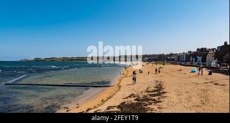 North Berwick, East Lothian, Écosse, Royaume-Uni, 24 avril 2021. Météo au Royaume-Uni : le soleil au bord de la mer : le temps ensoleillé attire la foule dans la ville balnéaire malgré la brise fraîche qui souffle depuis la mer du Nord, tandis que les gens apprécient l'assouplissement des restrictions de verrouillage. Photo : les gens sur East Beach malgré le vent froid Banque D'Images