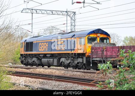 Classe 66, près de Hitchin, fournissant une assistance arrière pour un long train lourd de ballasts et de traverses en béton pour le remodelage de la Croix du Roi de Londres Banque D'Images