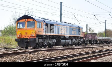 Classe 66, près de Hitchin, fournissant une assistance arrière pour un long train lourd de ballasts et de traverses en béton pour le remodelage de la Croix du Roi de Londres Banque D'Images