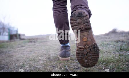 Les bottes ont tiré sur un randonneur qui marche sur une colline dans météo de la fin de l'automne Banque D'Images