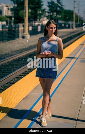 Bleu foncé Teen attendant un train Banque D'Images