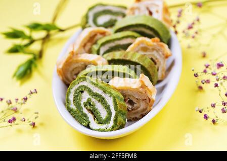 Emballage de légumes frais traditionnel de pâques avec garniture aux épinards, au fromage, à la crème et aux légumes sur plaque ovale sur fond jaune avec brindilles et feuilles. Banque D'Images