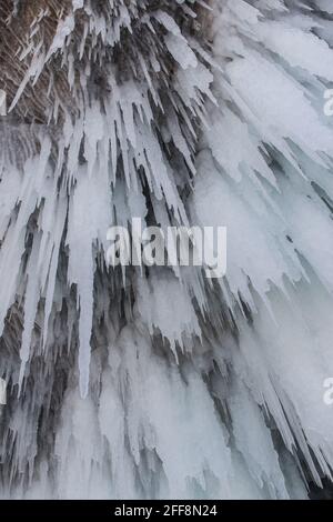 La roche sur le lac gelé Baikal est recouverte d'une épaisse couche de glace bleue: De nombreuses glaces et éclaboussures Banque D'Images