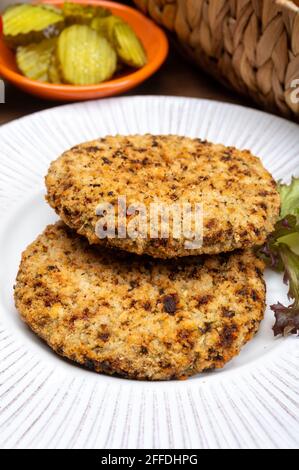 Préparation de hamburgers végétariens avec des patties rondes ou hamburgers à base de céréales, légumes et légumineuses Banque D'Images