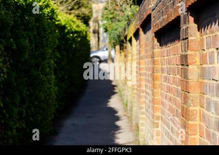 Ruelle mystérieuse et étroite en brique vers l'église Saint-Nicolas à Barton le Clay Banque D'Images