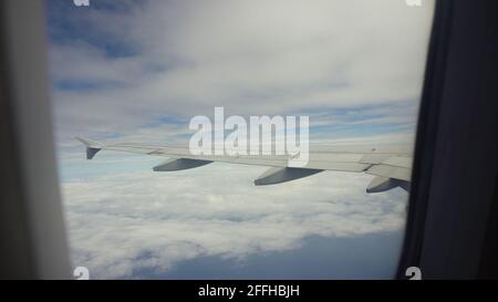 Hublot de l'avion avec bleu de la mer ou l'océan et d'îles tropicales. À la fenêtre par avion au cours du vol. Aile d'avion à travers le hublot. À la recherche d'aéronefs par la fenêtre pendant le vol. Banque D'Images