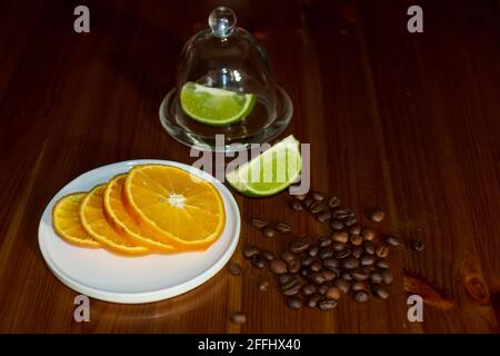 Tranches d'orange et de limes avec des grains de café sur des tables en bois. Banque D'Images