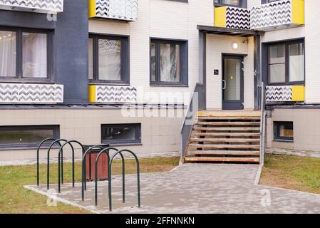 Entrée à un nouvel immeuble. Entrée avec parking à vélo et urne. Entrée à la maison par des escaliers. Porte vitrée à l'entrée. Banque D'Images