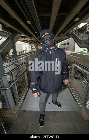 Masque noir clouté sur un homme vêtu de noir, pull à capuche Banque D'Images