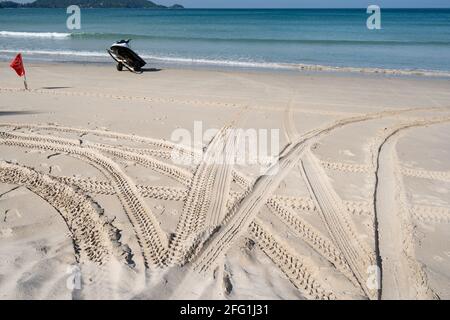 Pistes de pneus 4x4 sillonnantes pistes de pneus sur le fond de la texture de sable en été sur la texture de sable de la plage. Banque D'Images