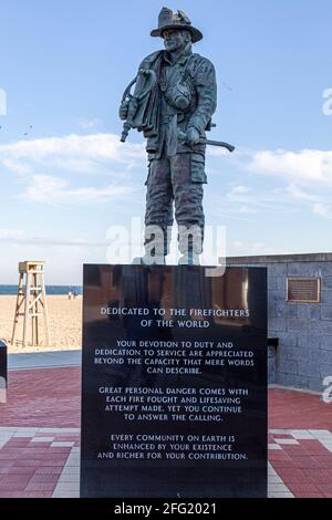 Ocean City, MD, États-Unis 04-18-2021: Statue de Figherfigher avec un personnel d'équipe d'incendie et de sauvetage avec équipement complet et un tuyau. Dédié aux pompiers Banque D'Images