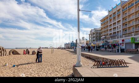 04-18-2021 Ocean City, MD, Etats-Unis: Un jeune couple s'enserre sur la plage de sable d'Ocean City, Maryland, au cours d'un après-midi agréable. En arrière-plan, je Banque D'Images