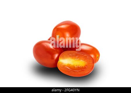 Vue latérale pile de tomates entières et demi-prune sur fond blanc avec passe-cheveux. Tomates ou Solanum lycopersicum ou lycopersicon esculentum a Banque D'Images