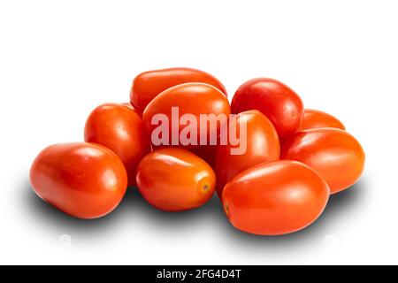 Vue latérale pile de tomates prune mûres de forme ovale isolée sur fond blanc avec passe-cheveux. Tomates ou Solanum lycopersicum ou lycopersicon escu Banque D'Images