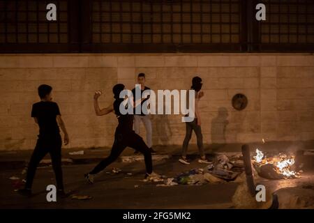 Bethléem. 24 avril 2021. Un manifestant palestinien lance des pierres contre des soldats israéliens et des membres de la police frontalière israélienne lors d'affrontements à la suite d'une manifestation anti-israélienne dans la ville de Bethléem, en Cisjordanie, le 24 avril 2021. Des affrontements ont éclaté dans les villes de Cisjordanie dans un climat de tensions suite à des affrontements à Jérusalem entre Palestiniens et Israéliens le 22 avril. Credit: Luay Sababa/Xinhua/Alamy Live News Banque D'Images