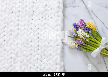 Bouquet de fleurs d'jacinthes de couleur ressort. Fond en marbre blanc et tissu écossais doux Banque D'Images