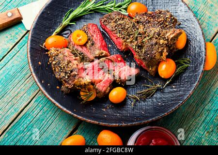 Steak de bœuf fraîchement coupé en tranches rôti au kumquat, au romarin et aux épices. Entrecote de veau sur une plaque Banque D'Images