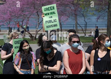 New York, États-Unis. 24 avril 2021. Un homme porte un panneau qui se lit comme « Green New Deal for public Housing » lors de la célébration du jour de la Terre à Astoria Park, dans le quartier Queens de New York. La congressiste Ocasio-Cortez, accompagnée par la sénatrice de l'État de New York Jessica Ramos et par le membre de l'Assemblée de New York, Zohran Mamdani, pour des remarques sur le NRG Energy, Proposition de l'Inc pour la centrale électrique Astoria. Le Congrès s'oppose aux efforts de NRG pour remplacer leur turbine vieille de 50 ans de l'usine de fabrication de « peaker » d'Astoria par un générateur qui brûle les combustibles fossiles extraits par fracturation hydraulique. Crédit : SOPA Images Limited/Alamy Live News Banque D'Images